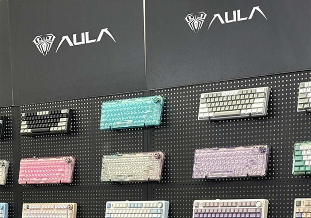 Display of various keyboards with AULA branding on a black background