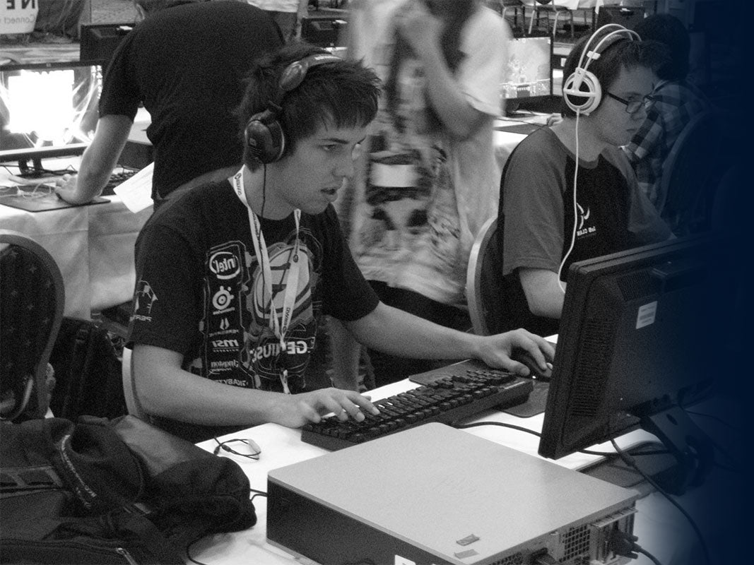 Close-up of a competitive gamer with a headset focused on playing during an esports tournament or LAN event.